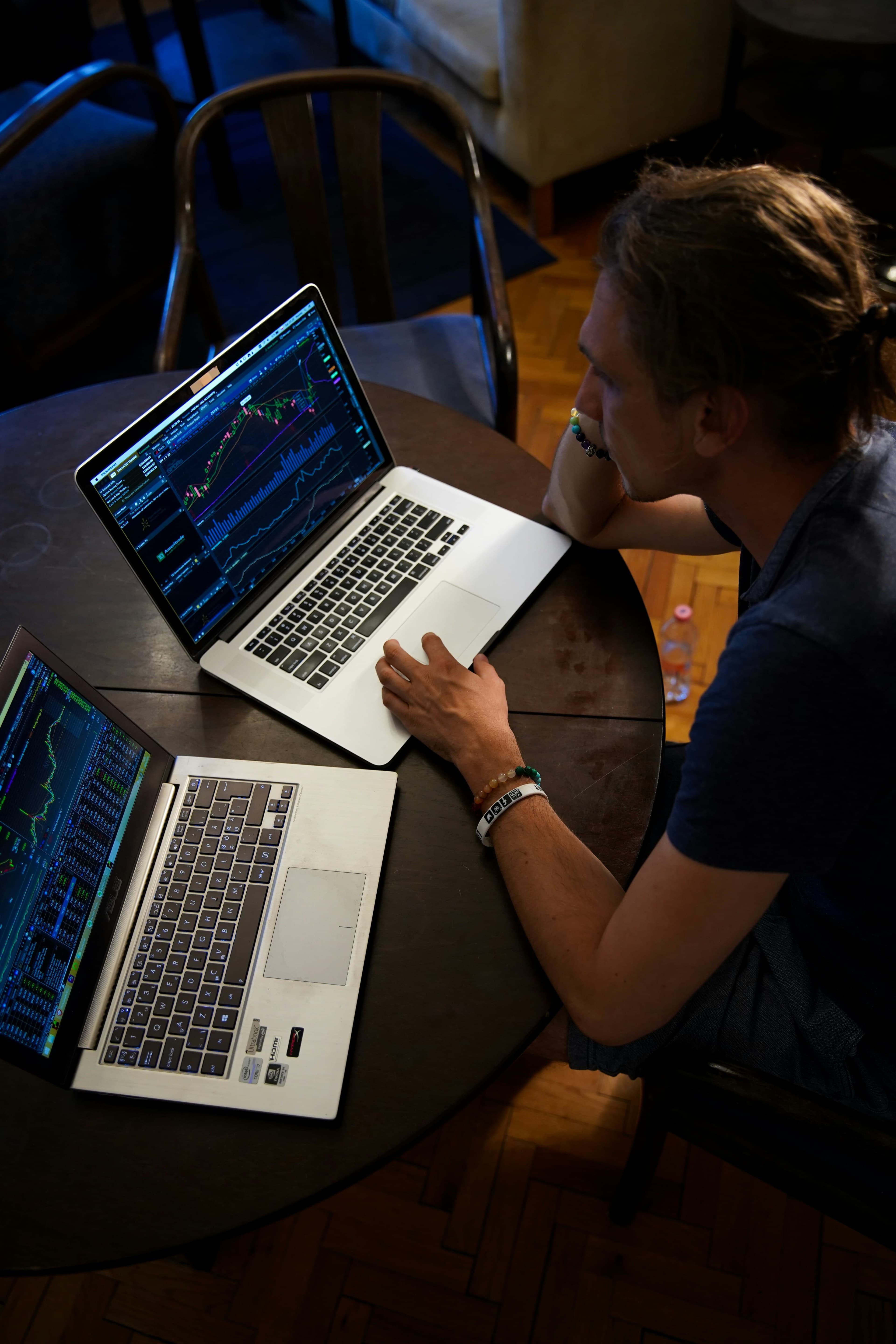 A man sitting in front of 2 laptops